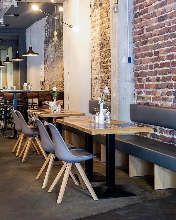 Gastraum des Restaurants Meat me mit Sitzbänken, Holztischen und Backsteinwand