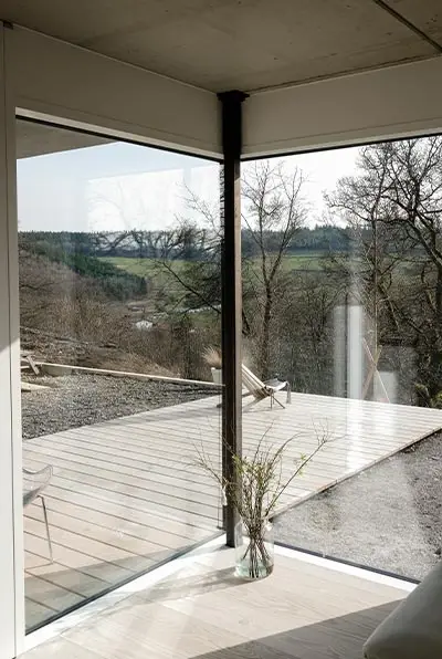 Verglaste Ecke mit Blick auf Terrasse und Landschaft
