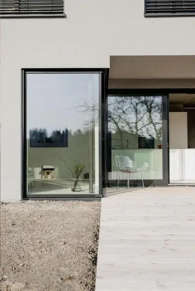 Hauszugang mit großem Fenster und Holzsteg