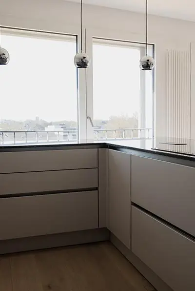Küche mit grifflosen Fronten vor dem Fenster