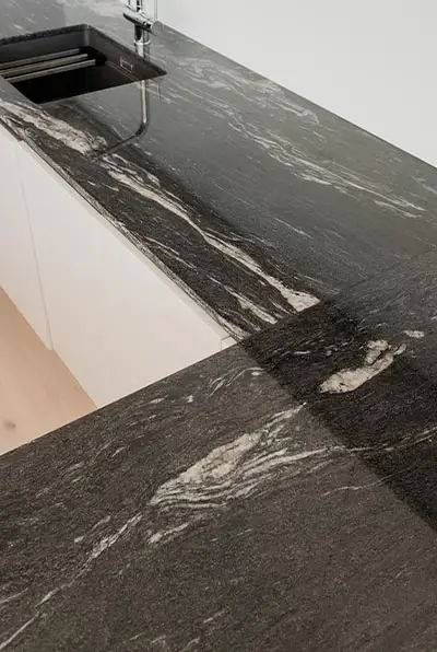 Detail der dunklen, geäderten Natursteinplatte