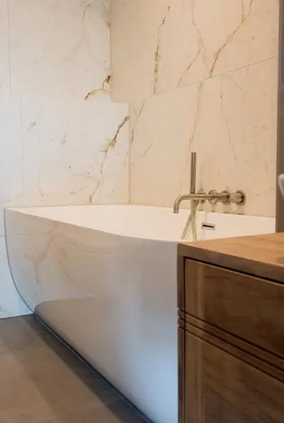 Badewanne neben einem Holzmöbel