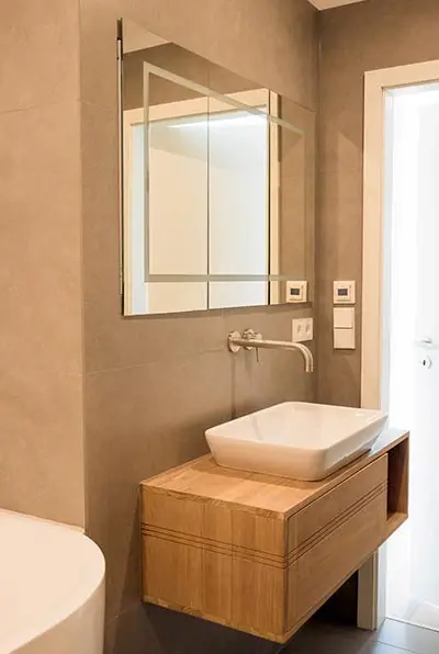 Waschplatz mit Holzunterschrank und Spiegel